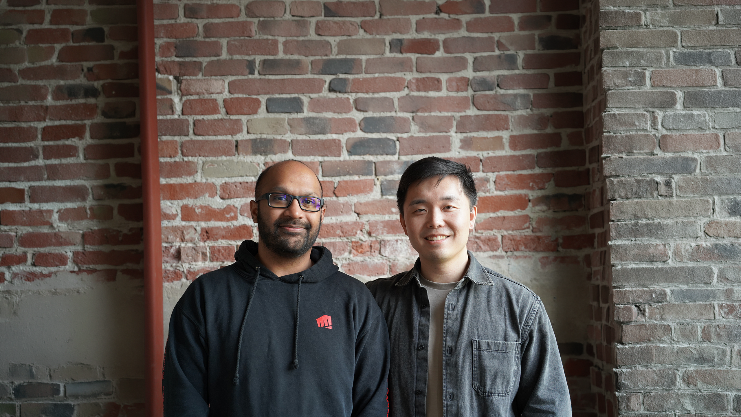 Frisson Labs co-founders Rohit Swamy and Charles Niu in front of a brick wall